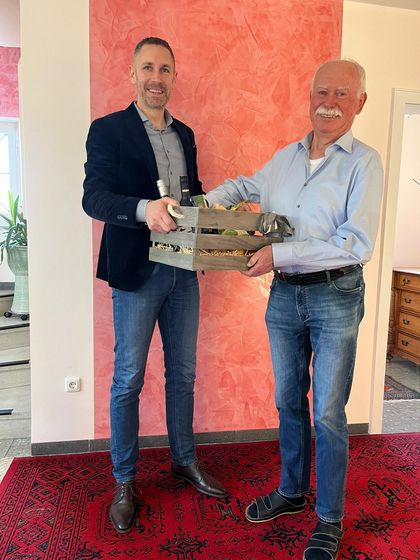 Bürgermeister Martin Bernreuther überreicht Hans-Friedrich Hacker einen Geschenkkorb