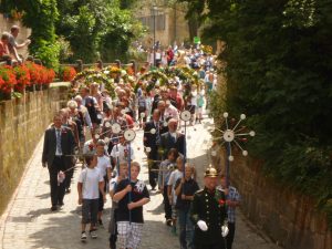 Festlicher Umzug in einer mit Blumen geschmückten Straße