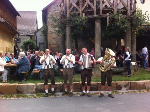 Musiker in Tracht spielen vor der Tanzlinde Langenstadt