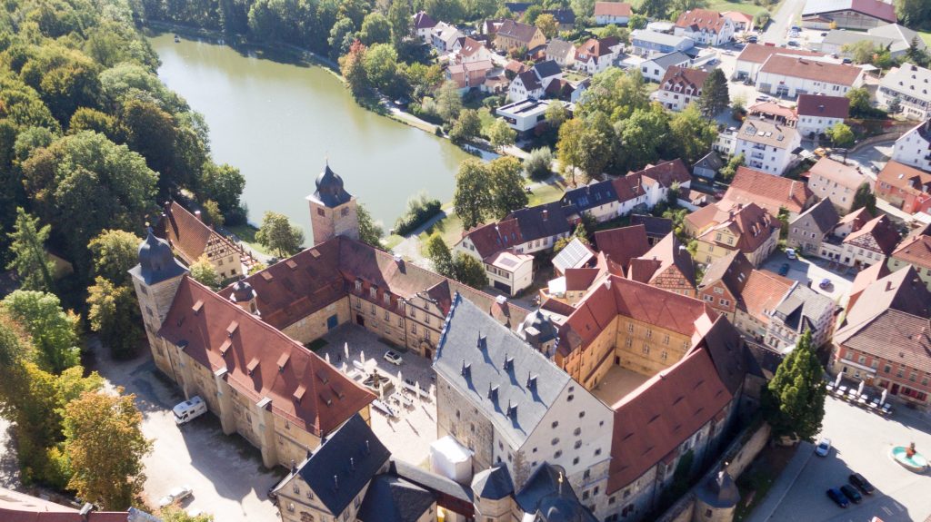 Dronenbild des Schlosses mit Kirchgang und Neptunbrunnen